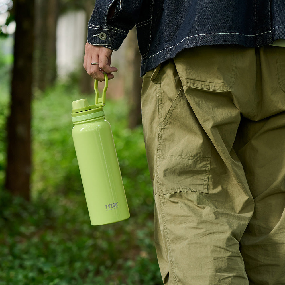 Person carrying the yellow TYESO AERIS REVIVE sports bottle outdoors #color_yellow