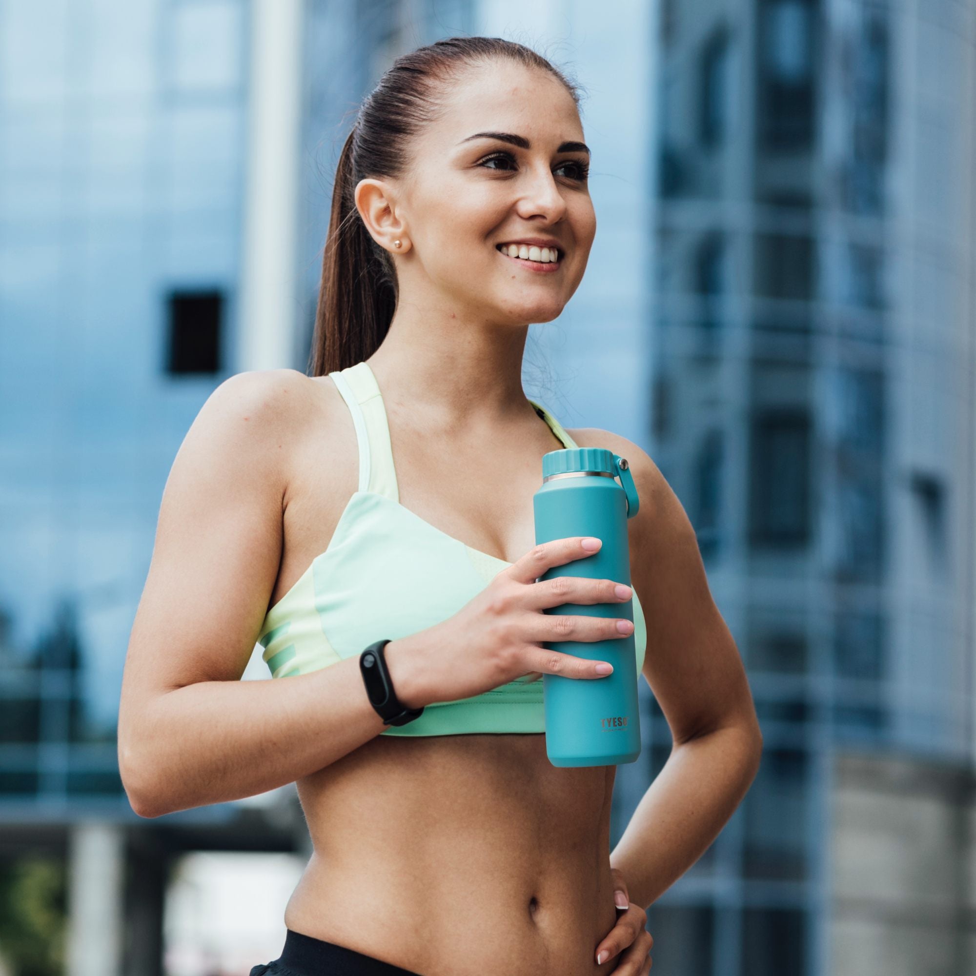 Athlete holding the blue 17 oz TYESO MESA sports water bottle after a workout #color_blue