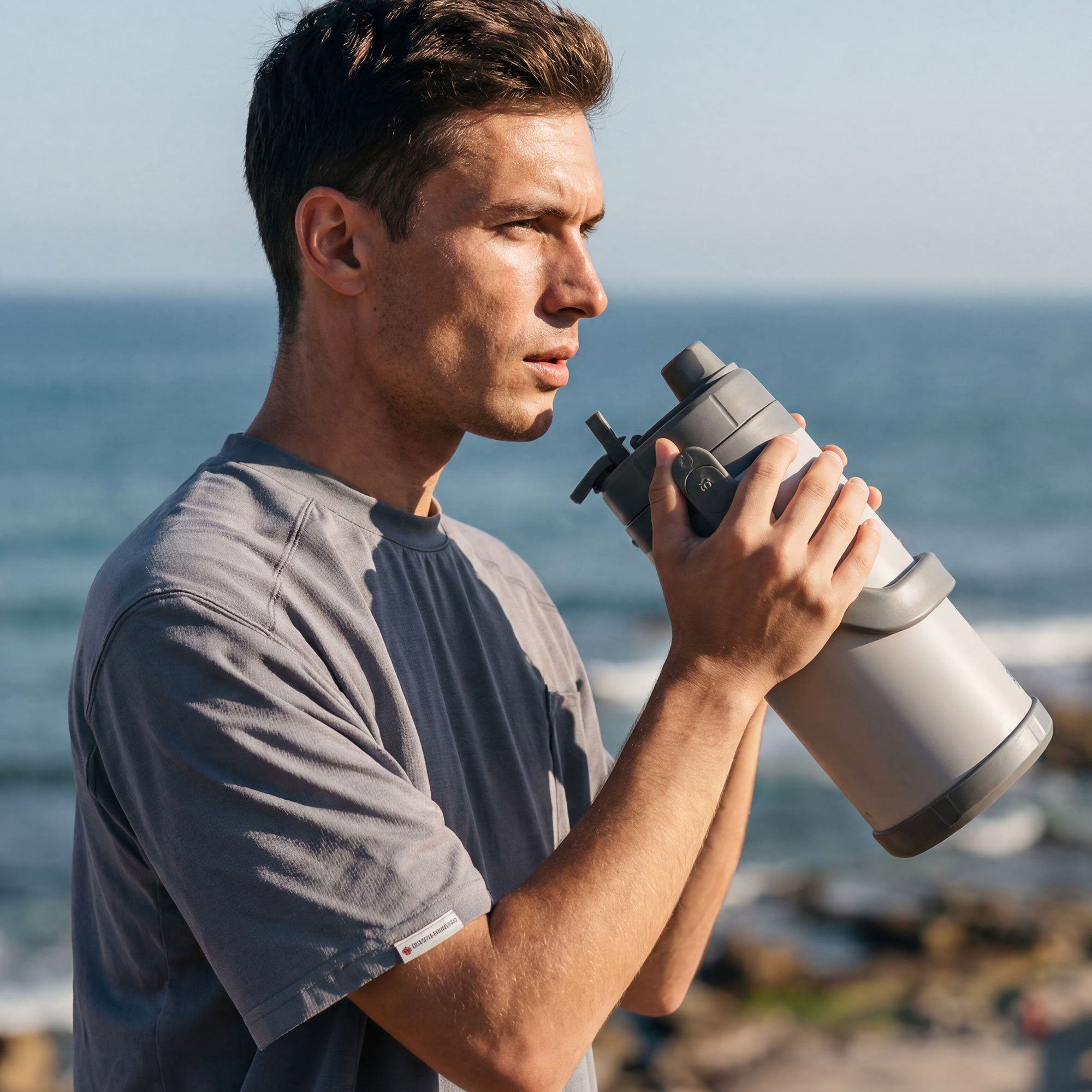 TYESO STOCK gray sports bottle in use with direct drinking spout #color_gray
