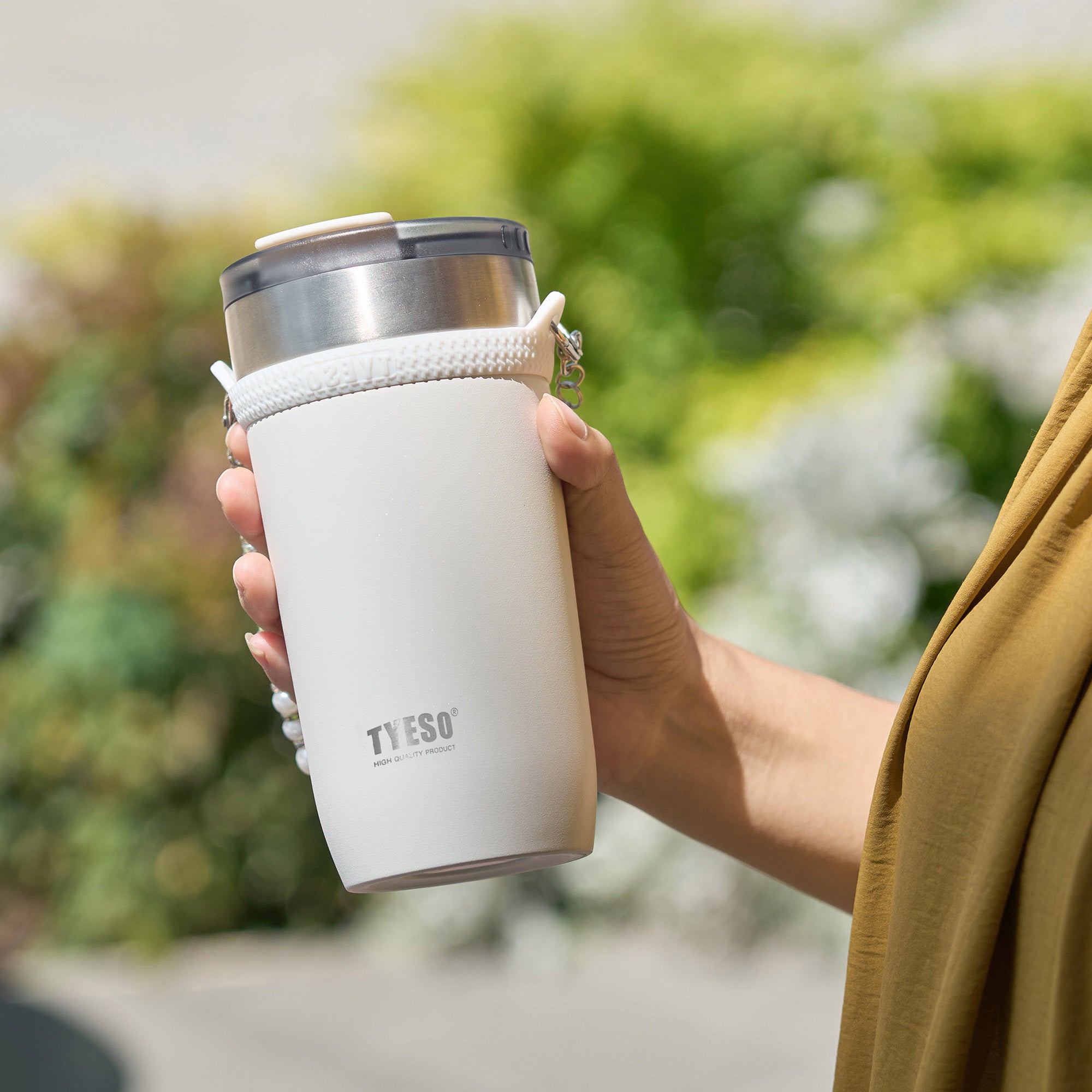 tyeso opaline insulated tumbler vacuum insulated BPA free white powder coating hand holding scene portable drink cup #color_white