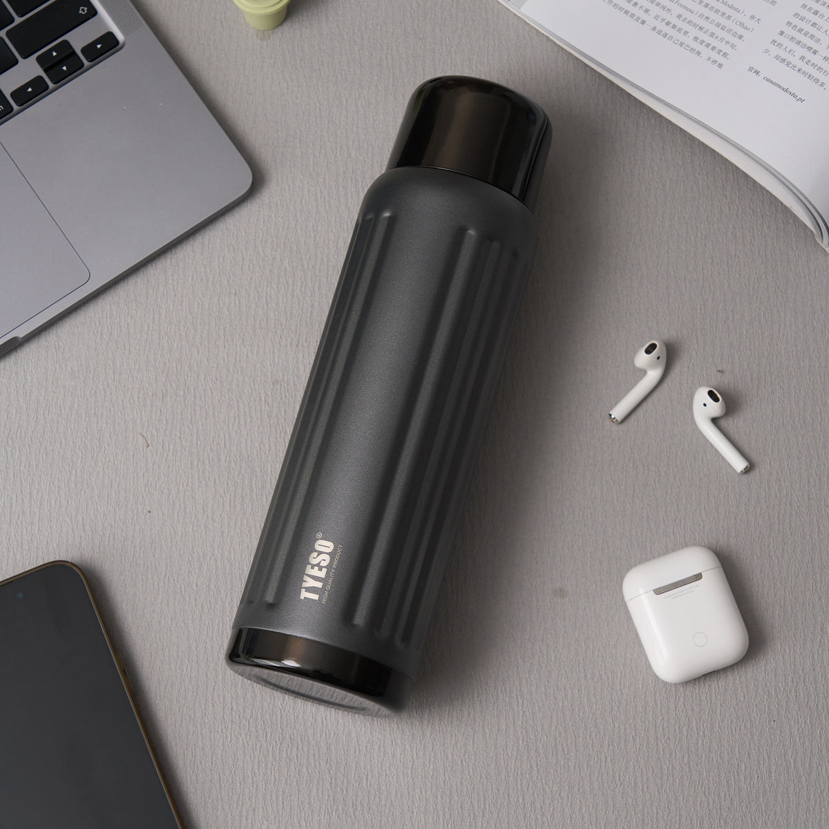 Shimmer Black FLUTE bottle beside everyday work essentials  #color_shimmer black